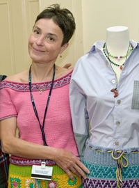 Carmen Patrascu standing next to a blue shirt, crocheted skirt, and handmade jewelry 